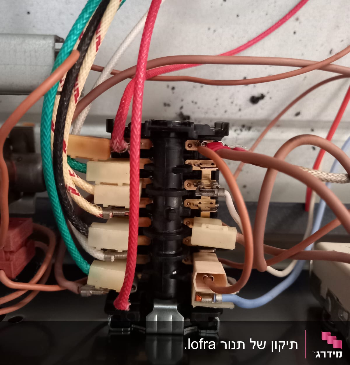 חוטי חשמל צבעוניים מחוברים למפסק חשמלי